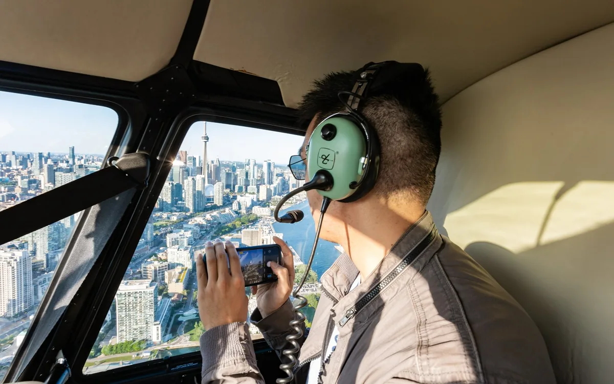 Un passeggero fotografa Toronto attraverso il finestrino di un elicottero